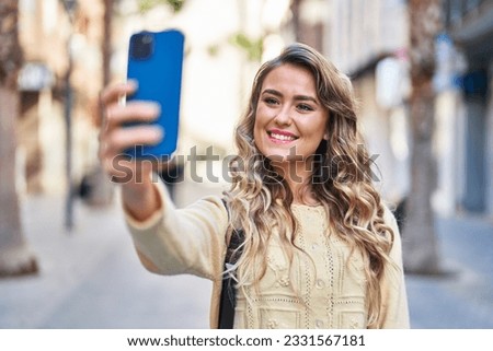 Young woman tourist making selfie by the smartphone at street