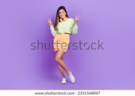 Full length photo of pretty adorable girl dressed green cropped sweatshirt showing v-sings listen songs isolated violet color background
