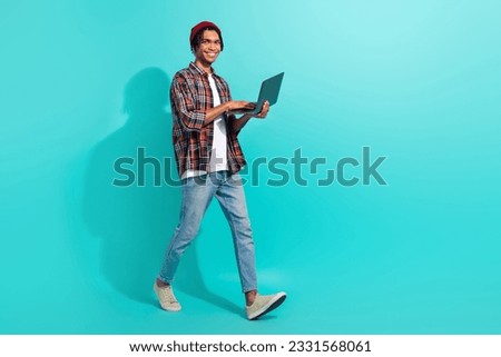 Full body profile photo of handsome man walking hold use netbook empty space advert isolated on teal color background