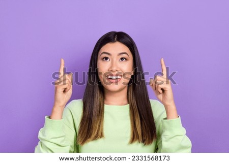 Photo of dreamy cute girl dressed green sweatshirt looking showing two fingers up empty space isolated violet color background