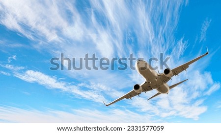 White passenger airplane flying in the sky amazing clouds in the background - Travel by air transport Royalty-Free Stock Photo #2331577059