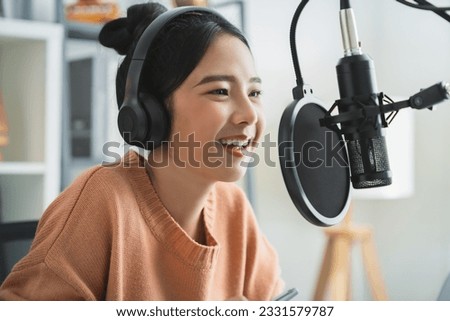 Young Asian woman use microphones wear headphones with laptop record podcast interview for radio. Content creator concept.