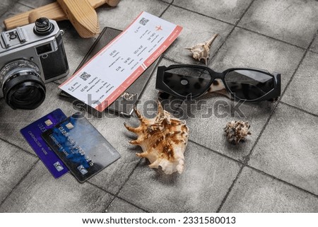 Composition with credit cards, ticket, sunglasses and seashells on grunge tile background
