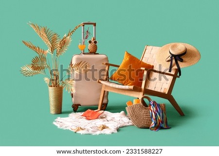 Suitcase with chair, fresh orange juice and beach accessories on turquoise background. Travel concept Royalty-Free Stock Photo #2331588227
