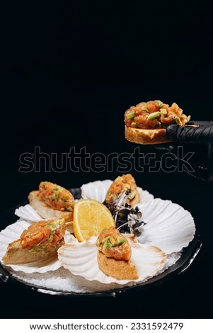 Salmon and avocado tartar in hand over the dish