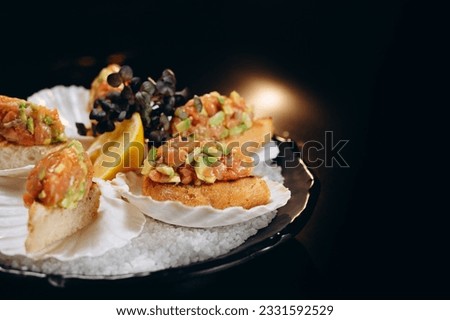 Cold fish appetizer Salmon and avocado tartar with lemon