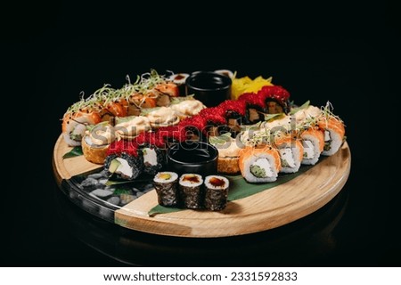 Unagi sushi Set on a wooden board with Philadelphia with salmon, California Black, crunch roll with shrimp, maki with avocado
