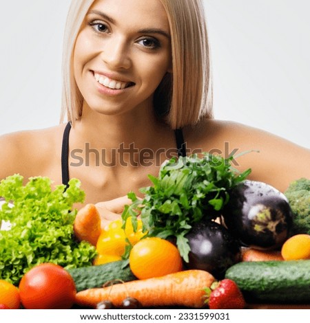 Portrait of happy smiling young beautiful blond woman with healthy vegetarian food, isolated over grey background. Girl in dieting, loss weight and healthy eating concept. Square.