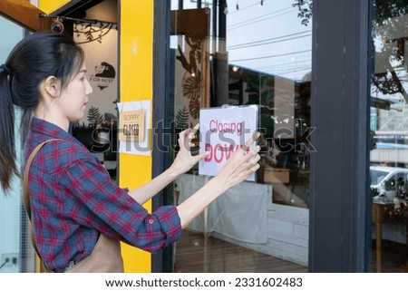 Beautiful woman owner of small coffee shop puts up sign closing down of business, Close store due to lockdown, quarantine of covid. Economic crisis after epidemic. restaurant entrepreneur concept.