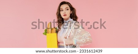 housewife concept, beautiful young woman holding reusable mesh bag with groceries, stylish wife doing daily house duties, standing on pink background, looking away, role play, banner