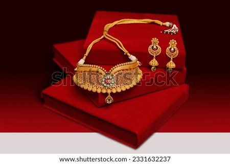 gold necklace with red and black background Royalty-Free Stock Photo #2331632237