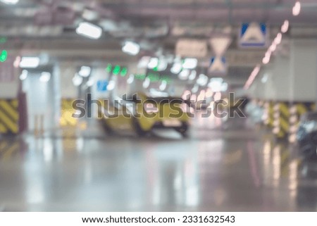 Abstract blurred car parking, garage, interior of underground parking with moving cars in building of shopping mall. With place for your text, for Defocused background