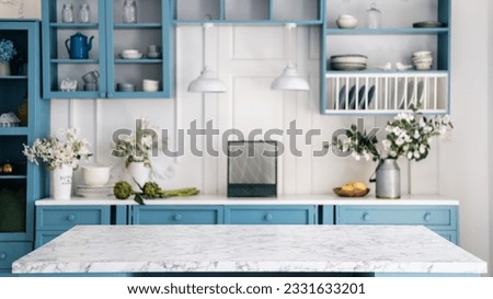 Empty marble kitchen island with clean surface in blue vintage kinchen in provence style. Dining table against blurred stylish furniture with drawers and kitchenware. Pendant lights hanging above. Royalty-Free Stock Photo #2331633201