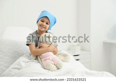Childhood cancer. Girl with toy bunny in hospital Royalty-Free Stock Photo #2331633521