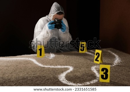 Criminologist in protective suit working at crime scene outdoors