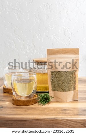 Pine needles tea in white cup. Healthy winter beverage in camping, pine tree needles tea in mug. Royalty-Free Stock Photo #2331652631