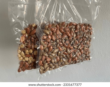 Nuts peanuts almonds in transparent bags vacuum made on white background and different alternative compositions on wooden background Macro Detail shot healthy lifestyle healthy eating buying now.