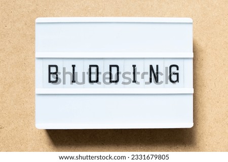 Lightbox with word bidding on wood background