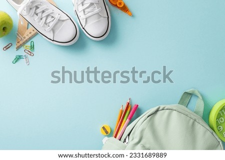 Educational essentials arrangement. Overhead image showcasing a rucksack, sneakers and abundant office supplies on an isolated pastel blue surface. Copy-space available for text or advertisements