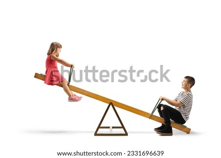 Little girl playing on a seesaw with an older boy isolated on white background Royalty-Free Stock Photo #2331696639