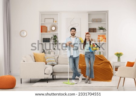 Spring cleaning. Couple with detergents and mop in living room Royalty-Free Stock Photo #2331704551