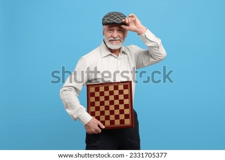 Man with chessboard on light blue background