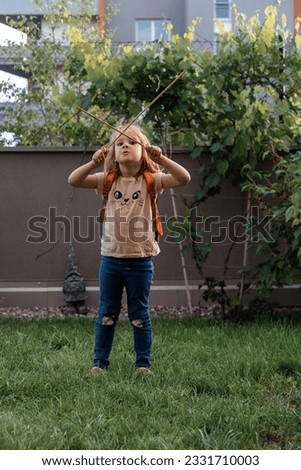 A pretty little girl playing in the yard. Photo taken in Prague in 2023