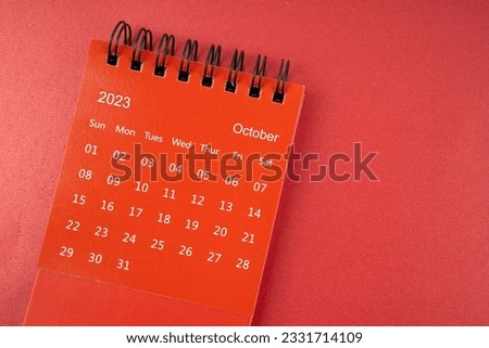 Red Ocotber 2023 desk calendar for the organizer to plan and reminder on red background.