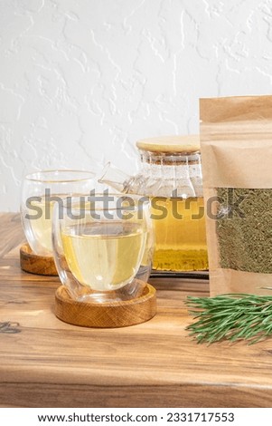 Pine needles tea in white cup. Healthy winter beverage in camping, pine tree needles tea in mug. Medicine scurvy, source of vitamin C and carotene. High quality photo Royalty-Free Stock Photo #2331717553