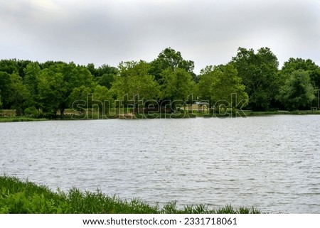 A peaceful calm pond in a public park in Missouri makes a quaint setting for a quiet stroll or meditation. Bokeh.