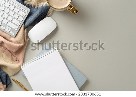 Experience coziness of freelance work in autumn with this top view picture featuring blank notepad with gilded pen, keyboard and glasses, hot cacao, scarf on grey isolated background with copyspace