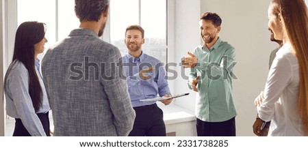 Business team having an interesting discussion. Group of happy, positive people talking about something and having fun during a work meeting in the office. Banner background. Business concept