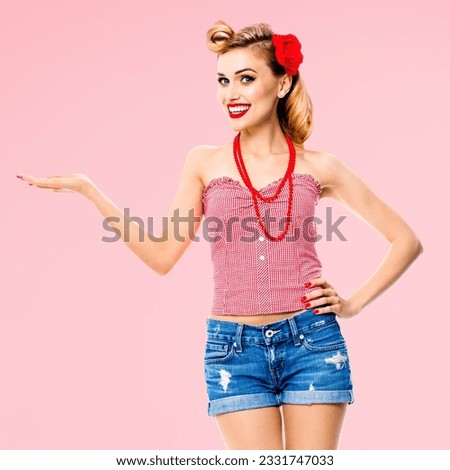 Square image - amazed happy woman holding, giving something. Excited girl in pin up, showing product or copy space for some text. Retro fashion and vintage. Rose pink colour back.
