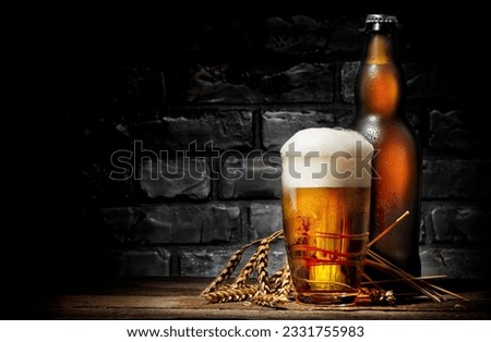 Beer in glass and bottle on wooden background