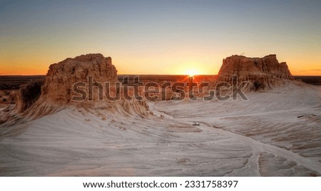 Sunset on the far horizon through raised desert formations at Mungo National Park in Australia