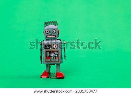 Retro robot toy on green background.