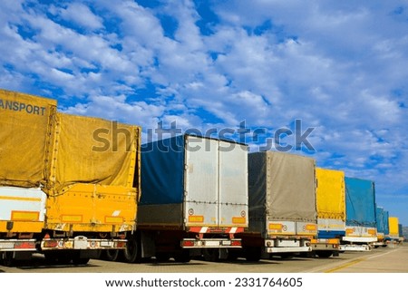 industry and commerce- trucks parked in a harbor Royalty-Free Stock Photo #2331764605