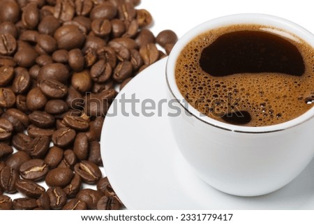 Cup of coffee and spilled out coffee beans on white background. Isolated.