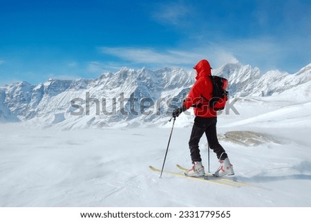 A lonely backcountry skier in a sunny winter day, alpine scenic, horizontal orientation