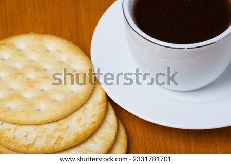 White cup of coffee and crackers.