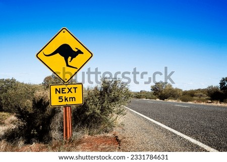 Kangaroo crossing sign by road in rural Australia.