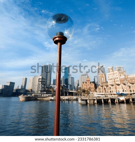 Lamppost in Sydney Cove with city skyline and water in Sydney, Australia.
