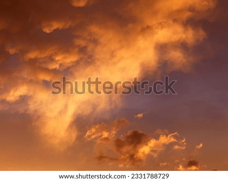 Orange-yellow clouds in sky at sunset.