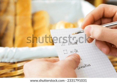 customer in a supermarket checking his shopping list