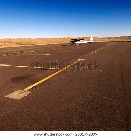 Plane in distance parked on tarmac at Canyonlands Field Airport, Utah, United States.