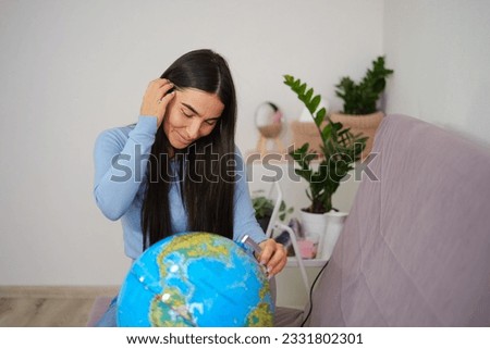 Traveling concept, Asian beautiful woman looking at globe ball in the bright room. High quality photo