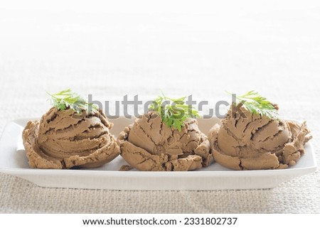 Brown ice cream in plate on dining table with copy space.