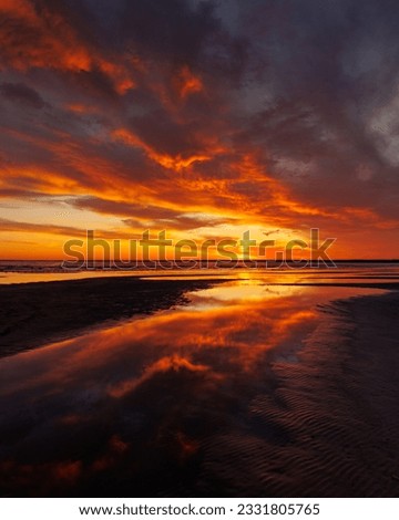 sunset sky with reflections in water, sunlight and colored orange clouds. Magnificent view of the sea and sun in evening. travel and freedom, meditation, poster. amazing sunset light on ocean Royalty-Free Stock Photo #2331805765