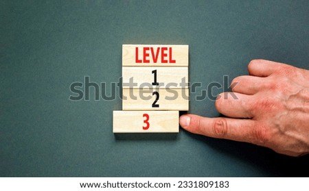 Time to level 3 symbol. Concept word Level 1 2 3 on wooden block. Businessman hand. Beautiful grey table grey background. Business planning and time to level 3 concept. Copy space. Royalty-Free Stock Photo #2331809183