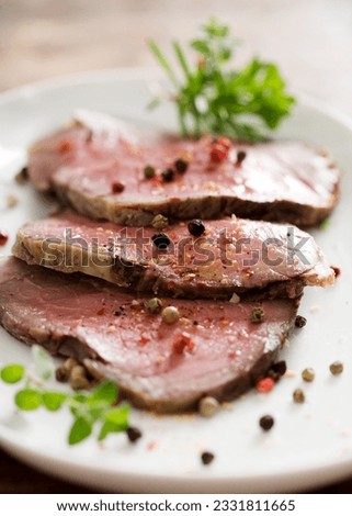 slices of juicy roast beef with herbs and pepper